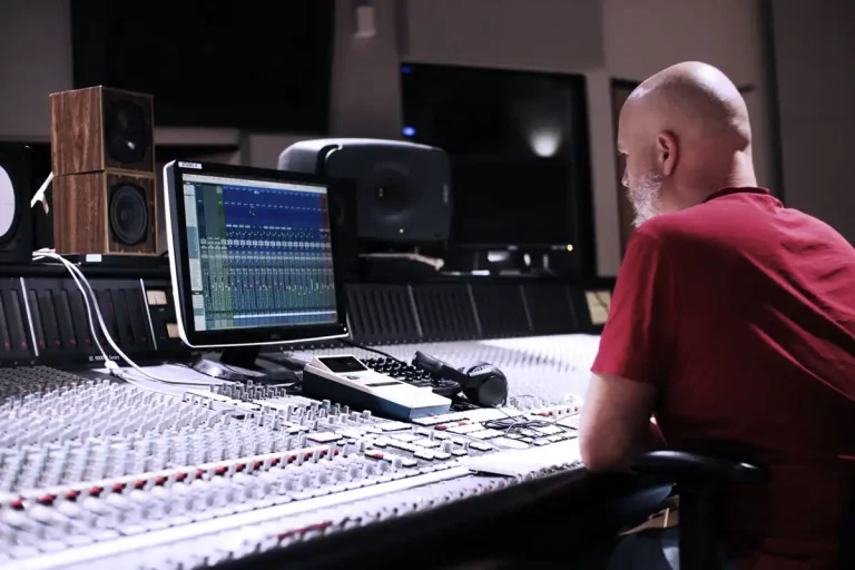 Home 2 Mix engineer adjusting levels at a studio mixing console